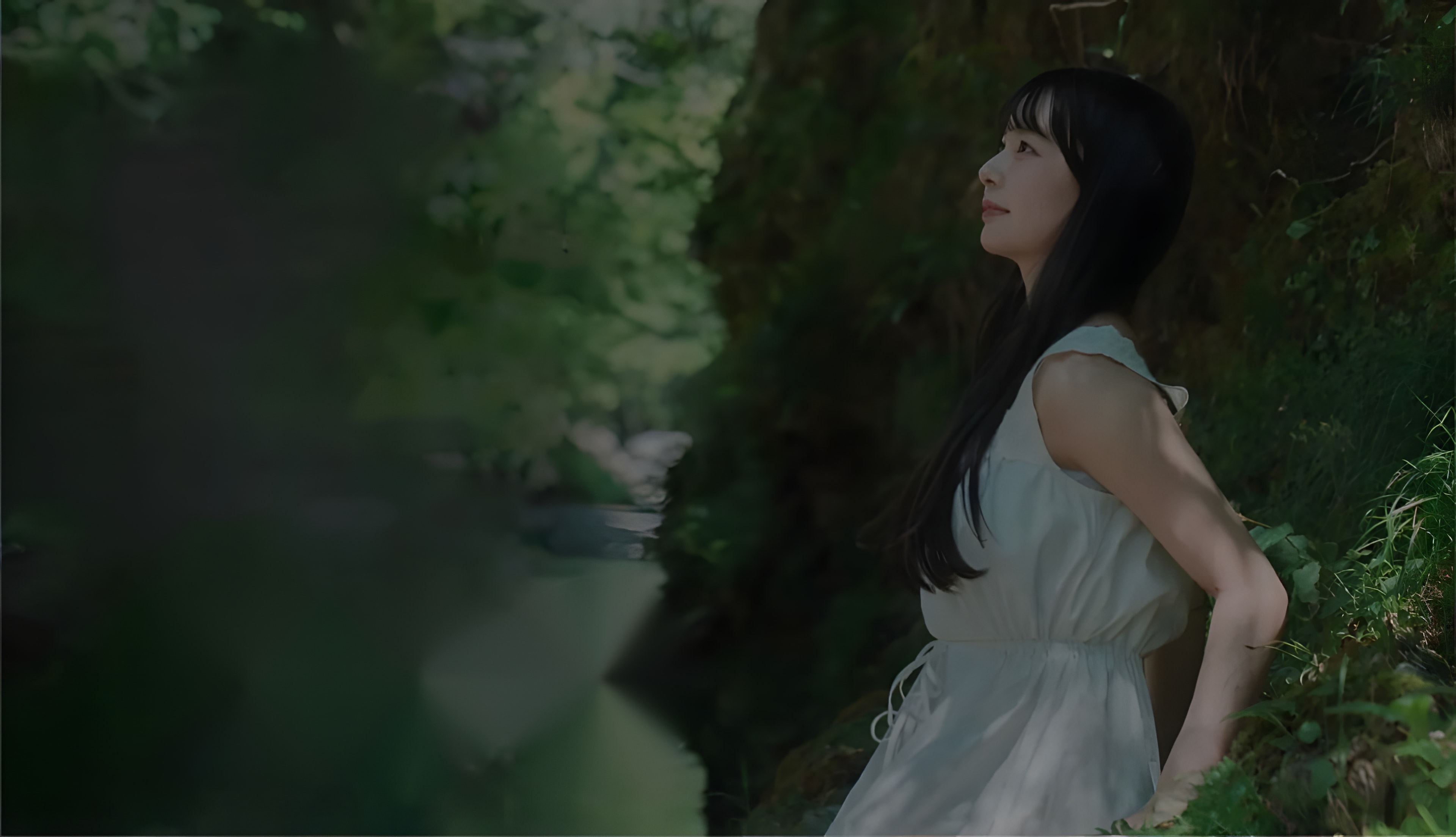 川辺の自然の中で佇む女性