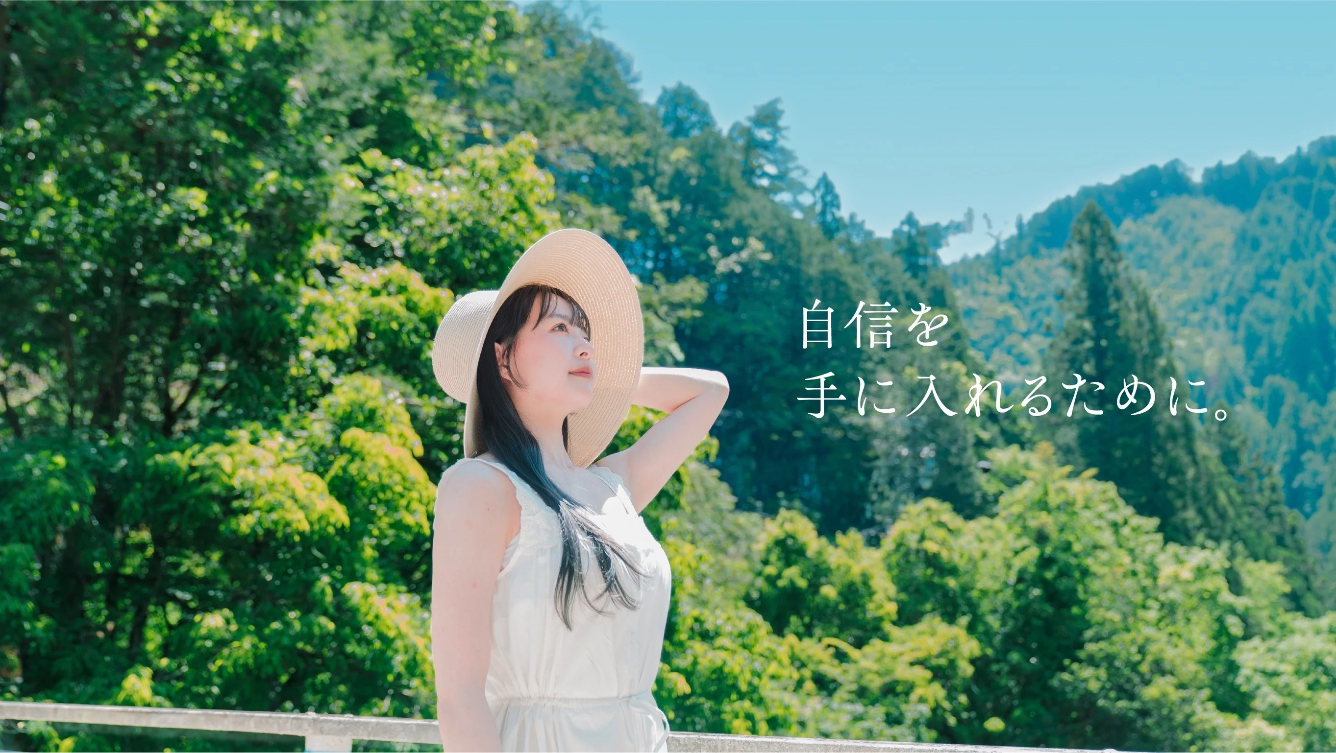 青空の下、帽子をかぶり前を見つめる女性
